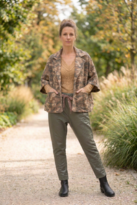 Veste camouflage légèrement plus oversize, avec les mains dans les poches et le top Beky camel